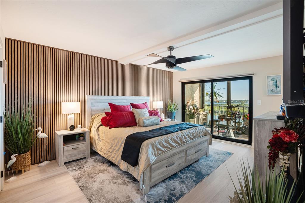 9397 Midnight Pass Road, Unit 905 Sarasota, FL 34242 - Photo 6 of 37 a bedroom with a large bed and a chandelier