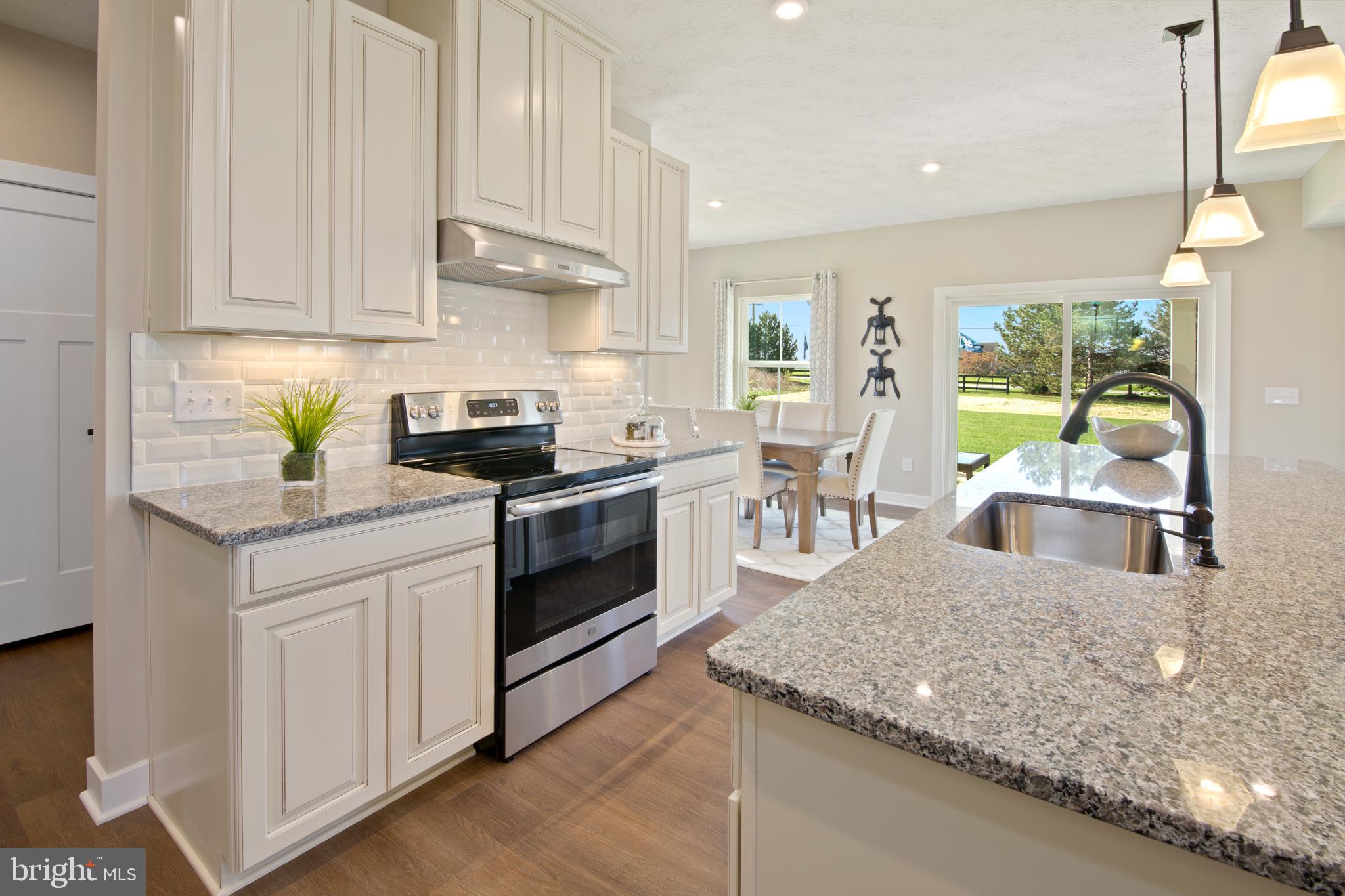 44 Wallace Way Ranson, WV 25438 - Photo 9 of 19 a kitchen with stainless steel appliances granite countertop a stove a sink dishwasher and white cabinets with wooden floor
