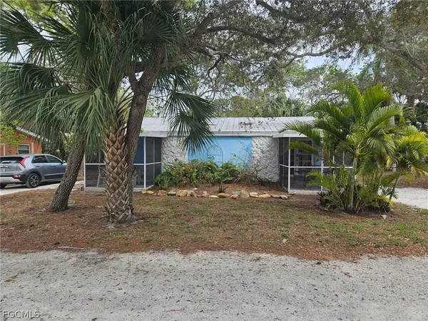 a view of a house with a yard and large tree