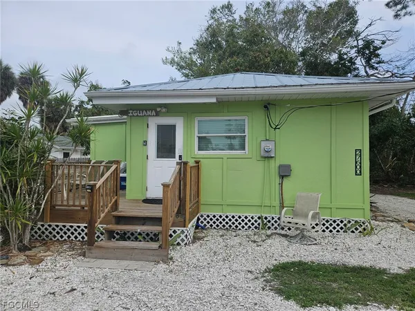 a view of a house with a small yard and wooden fence