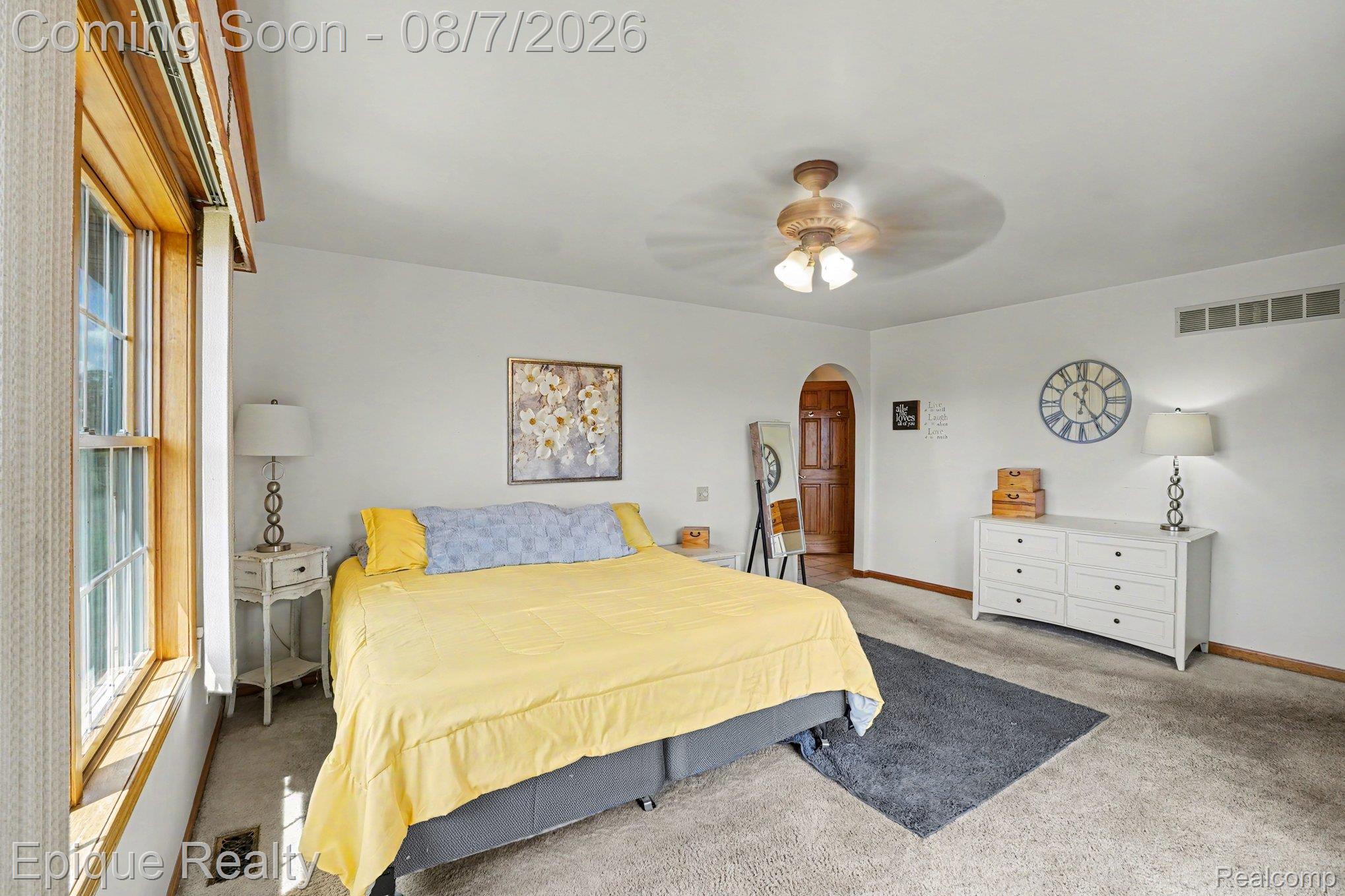 2288 Daley Road Lapeer, MI 48446 - Photo 10 of 30 Spacious room featuring light-colored carpeting, a window with wood-finish trim, and an arched doorway