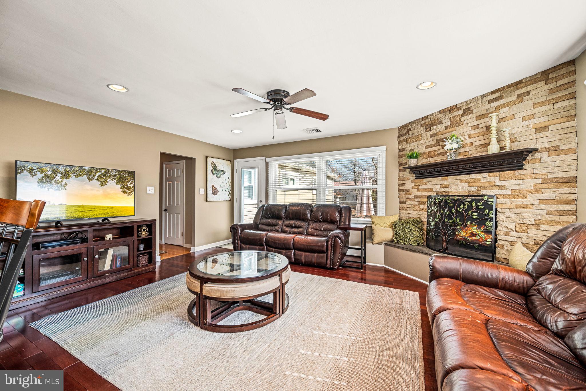 408 Scott Lane Wallingford, PA 19086 - Photo 5 of 39 a living room with furniture a fireplace and a flat screen tv