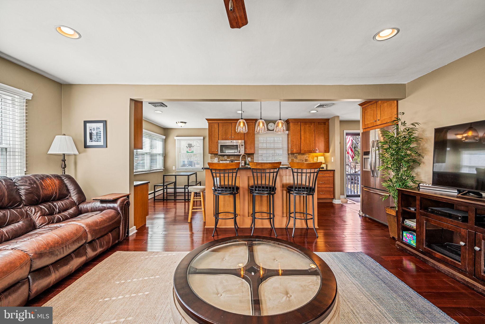 408 Scott Lane Wallingford, PA 19086 - Photo 7 of 39 a living room with furniture a flat screen tv and a floor to ceiling window