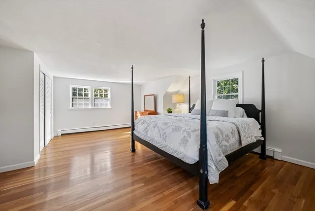 a spacious bedroom with a bed lamp closet and window
