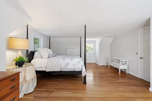 a bedroom with a bed lamps and wooden floor