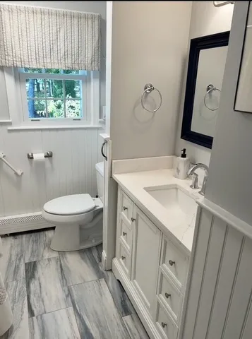 a bathroom with a sink toilet and window