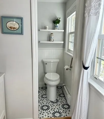 a bathroom with a toilet a window and a shower