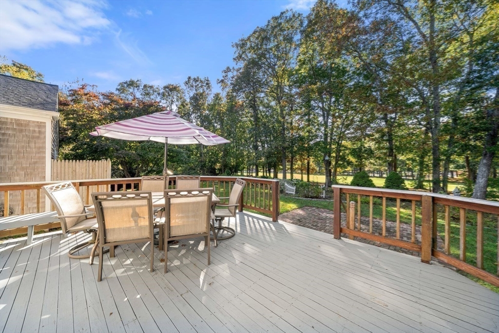 43 Canterbury Road Yarmouth, MA 02675 - Photo 23 of 25 a view of a patio with table and chairs under an umbrella with wooden floor