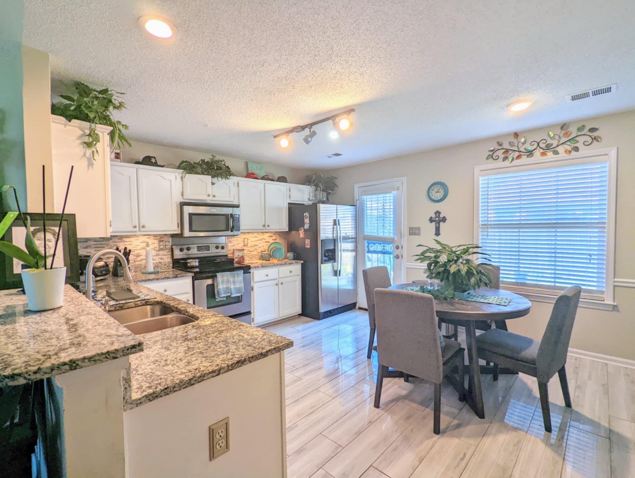 6894 Finch Road Memphis, TN 38141 - Photo 6 of 11 a kitchen with granite countertop sink table and chairs