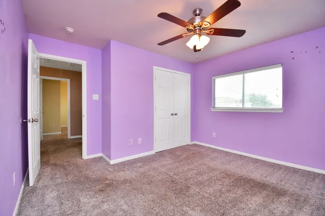 a view of a livingroom with a chandelier fan and a window