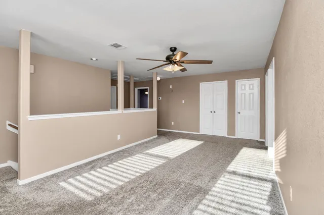 a view of a livingroom with a ceiling fan and window