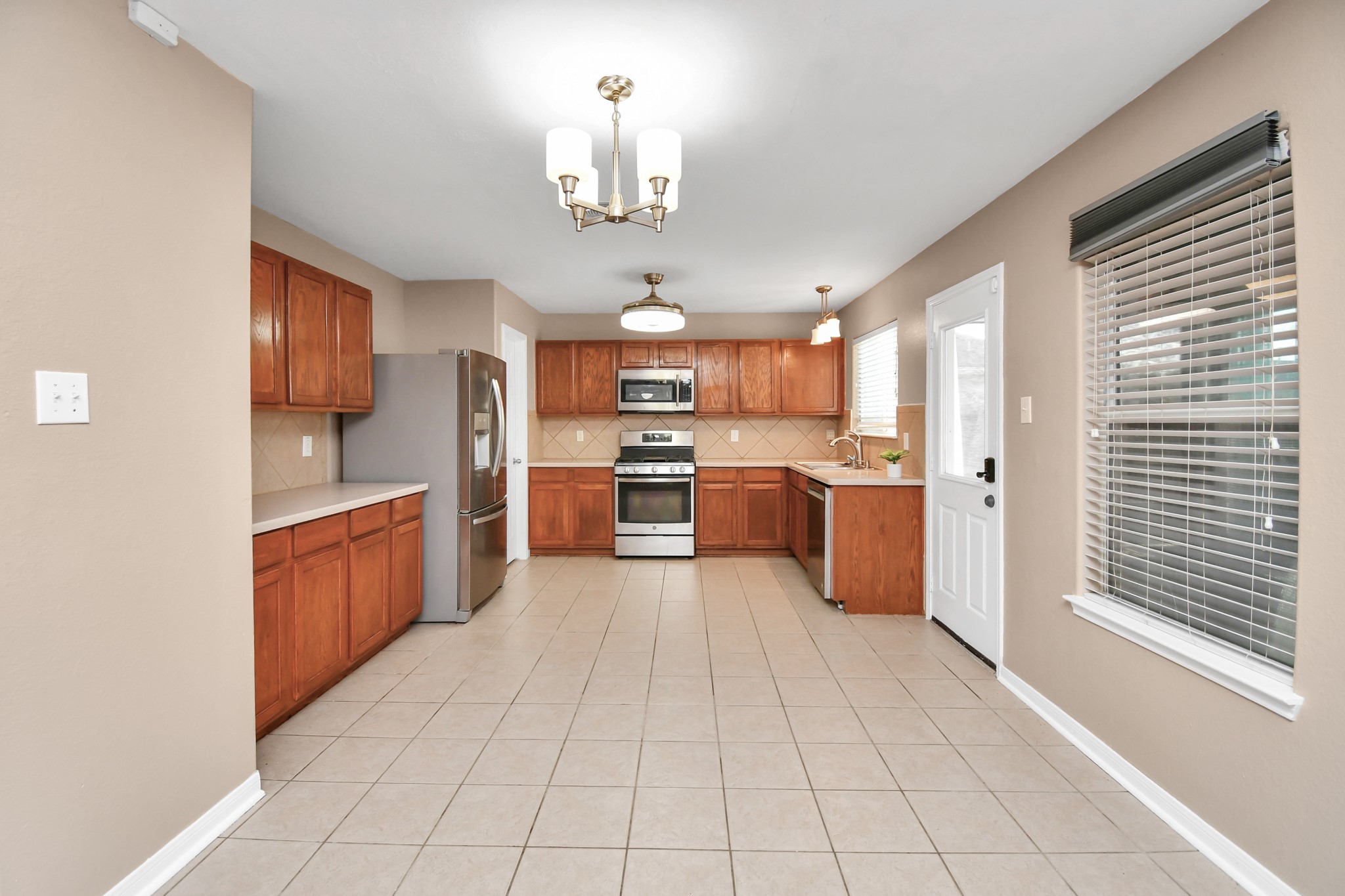 1118 Desert Palms Lane Rosenberg, TX 77471 - Photo 7 of 28 a large kitchen with stainless steel appliances granite countertop a stove a sink dishwasher and a refrigerator with wooden floor