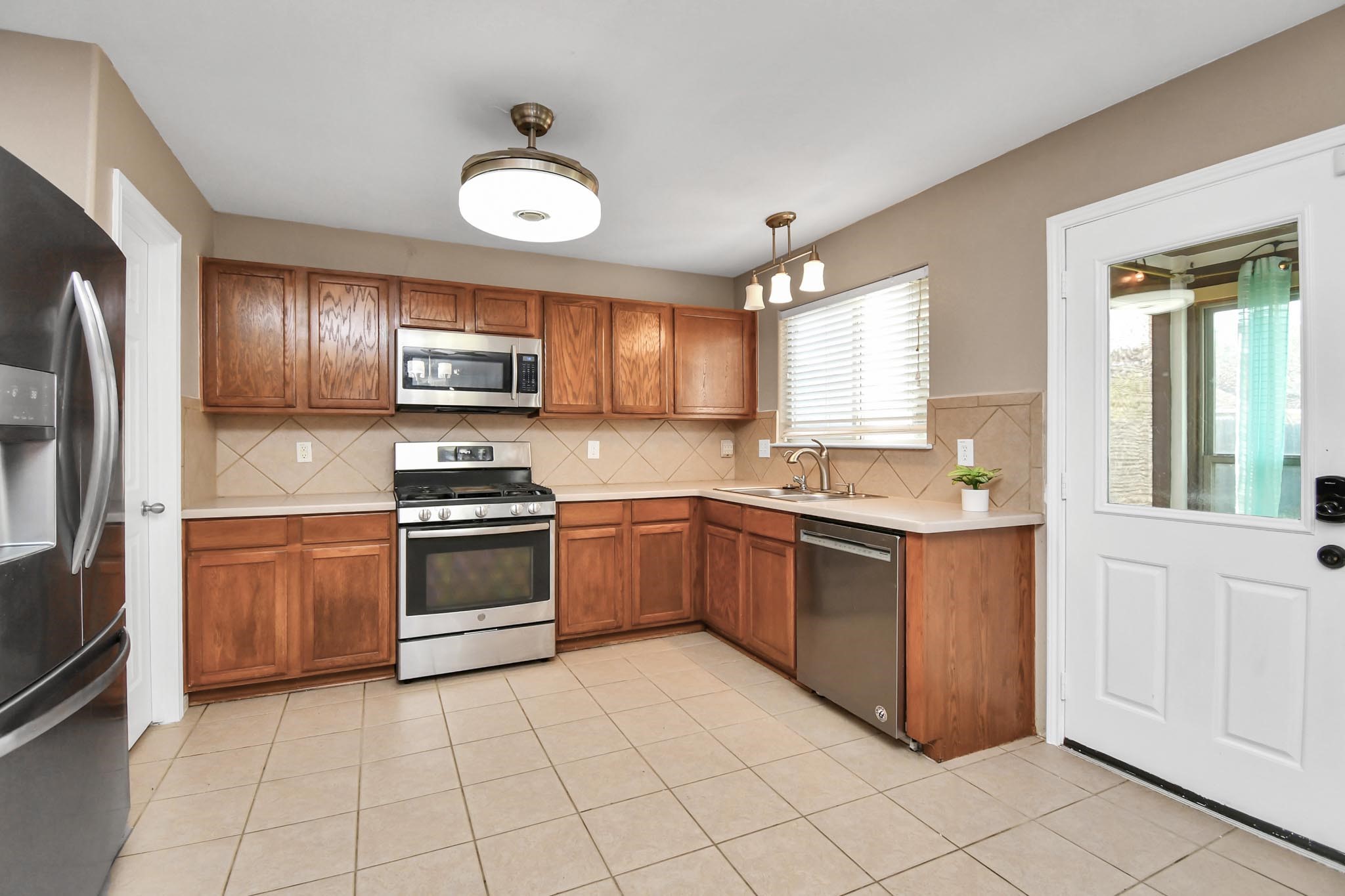 1118 Desert Palms Lane Rosenberg, TX 77471 - Photo 8 of 28 a kitchen with stainless steel appliances granite countertop a stove top oven a sink and a refrigerator