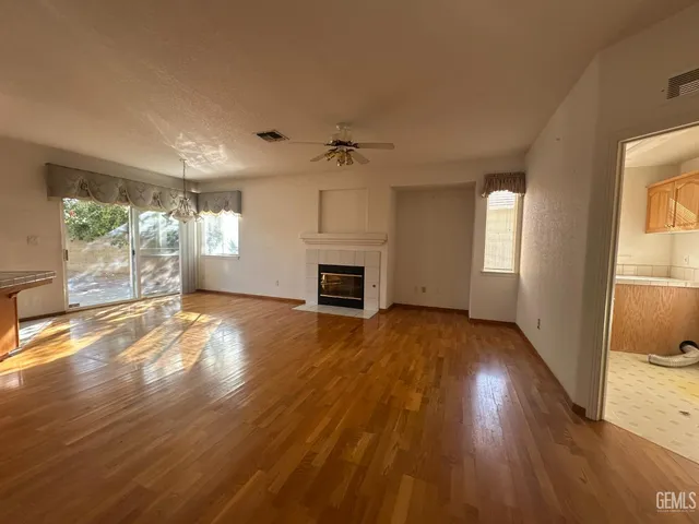 a view of empty room with wooden floor and fireplace