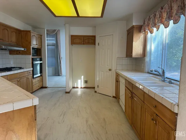 a kitchen with stainless steel appliances granite countertop a sink and a stove