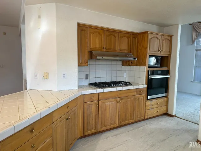 a kitchen with granite countertop a stove and a refrigerator
