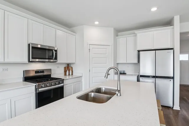 a kitchen with sink a refrigerator and cabinets