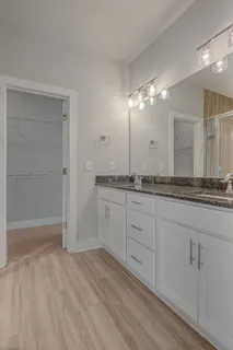 a spacious bathroom with a granite countertop sink and a mirror