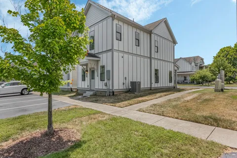 a view of a house with backyard and trees