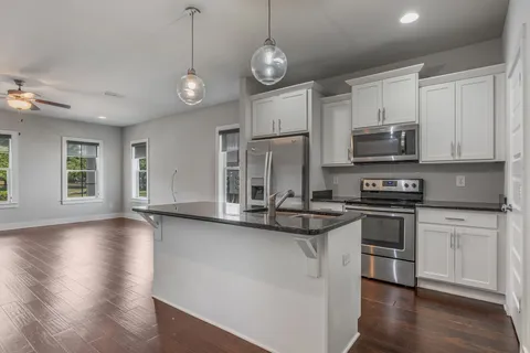 a kitchen with stainless steel appliances granite countertop a stove a sink and a refrigerator