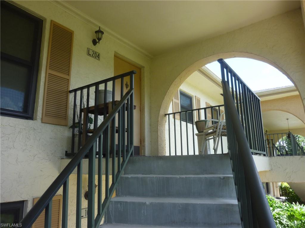 5560 Rattlesnake Hammock Road, Unit L204 Naples, FL 34113 - Photo 3 of 23 a view of staircase with railing and a chandelier