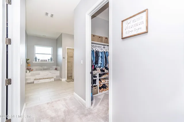 a kitchen with white cabinets appliances and a window