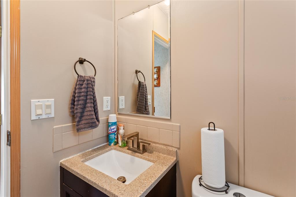 5670 Acadia Street Keystone Heights, FL 32656 - Photo 56 of 65 a bathroom with a sink a toilet and mirror