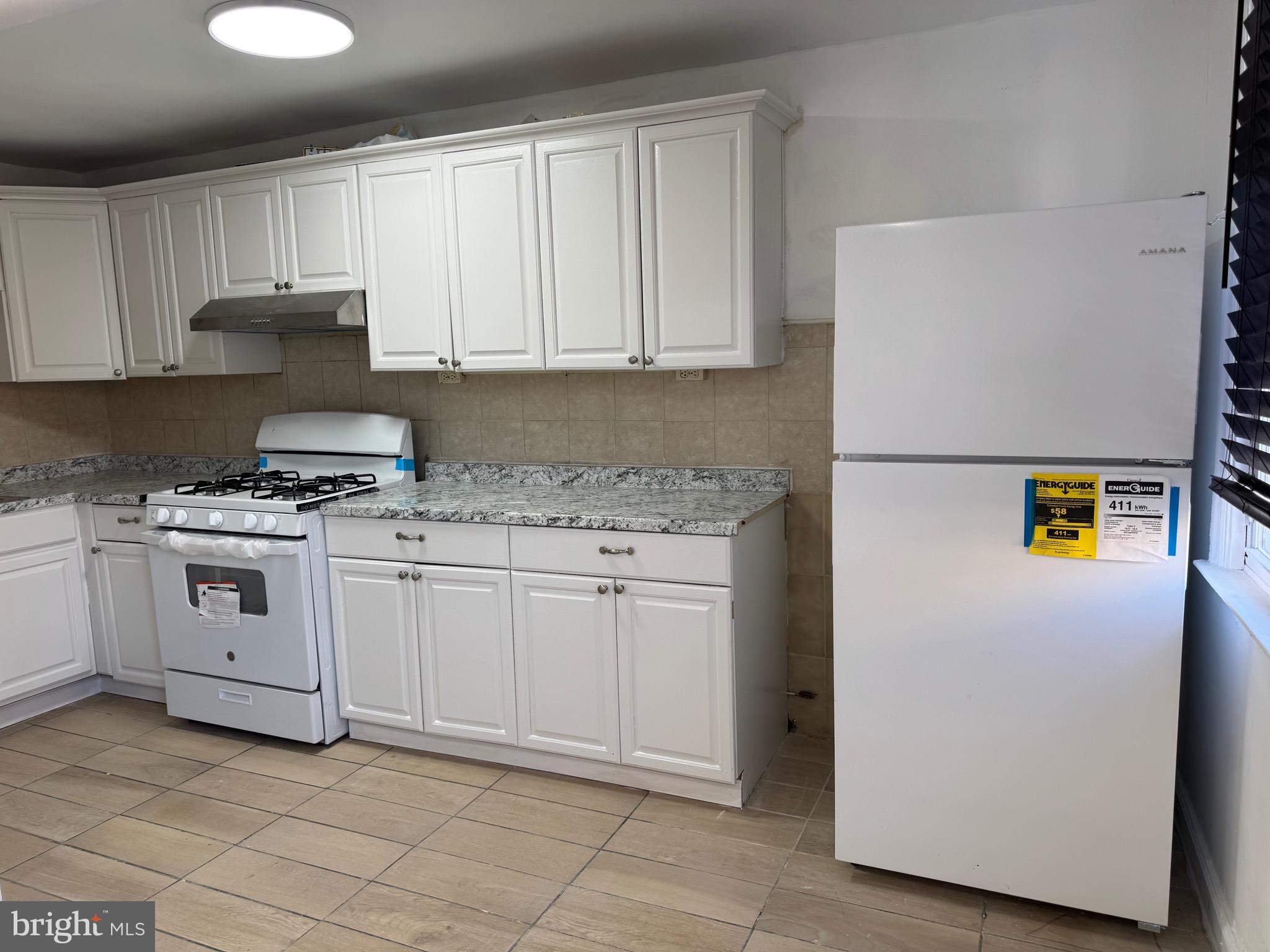 1203 Edgehill Road Darby, PA 19023 - Photo 3 of 24 a kitchen with granite countertop white cabinets and white appliances