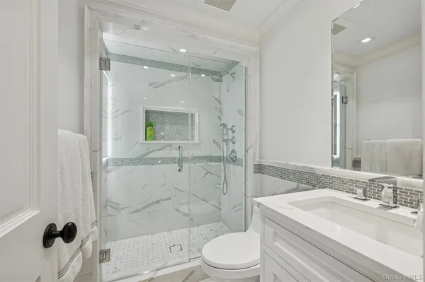 a bathroom with a sink a toilet and shower