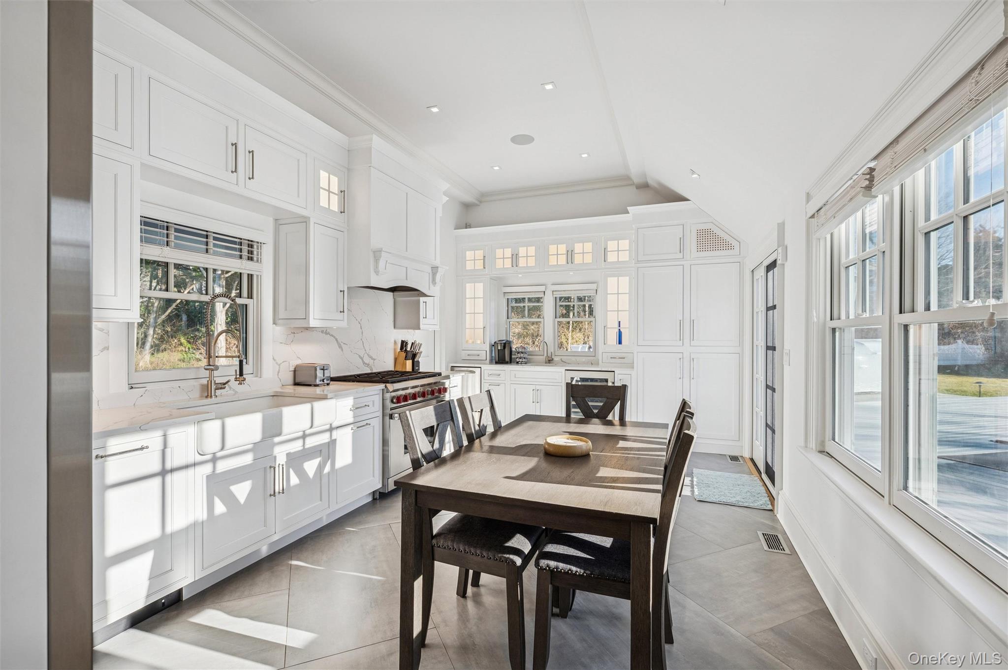 30 Club Lane Remsenburg, NY 11960 - Photo 2 of 19 a kitchen with stainless steel appliances granite countertop a stove a sink a refrigerator and white cabinets with wooden floor
