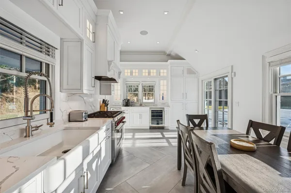 an open kitchen with granite countertop a sink and white cabinets