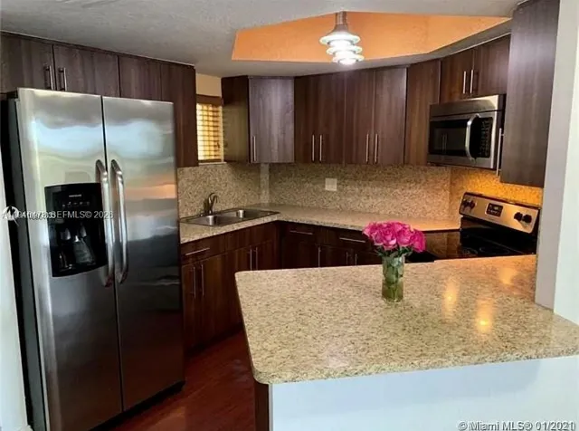 a kitchen with stainless steel appliances granite countertop a refrigerator a stove a sink and dishwasher