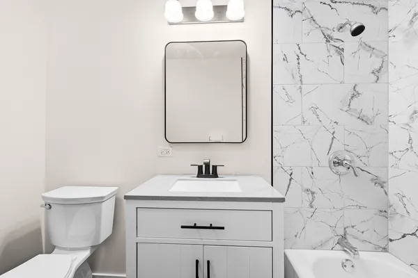 a bathroom with a sink toilet and mirror