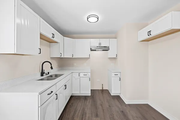 a kitchen with white cabinets and sink