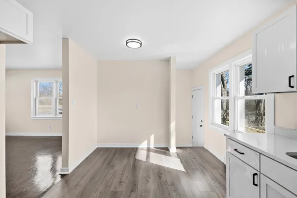 a view of a kitchen with wooden floor and electronic appliances