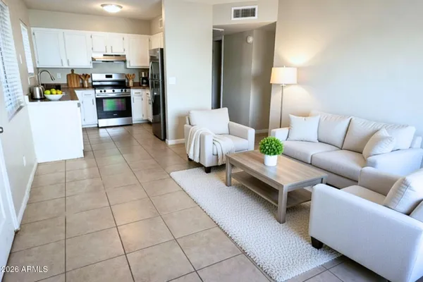 a living room with furniture and kitchen view