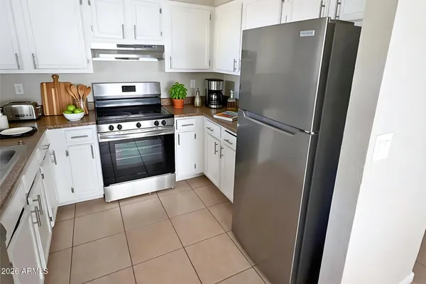 a white refrigerator freezer and a stove sitting inside of a kitchen