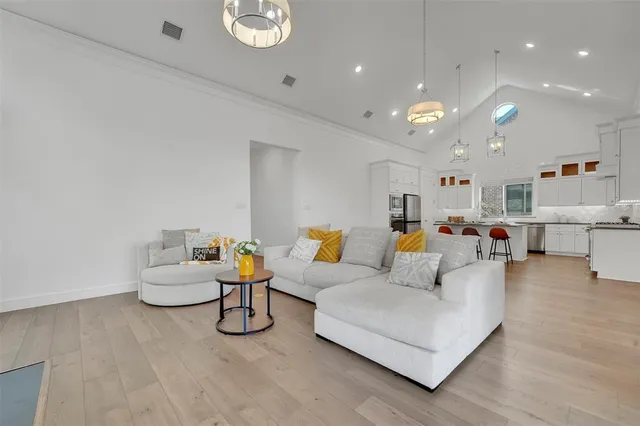 a kitchen with stainless steel appliances granite countertop a stove top oven a refrigerator a sink and a dining table with wooden floor