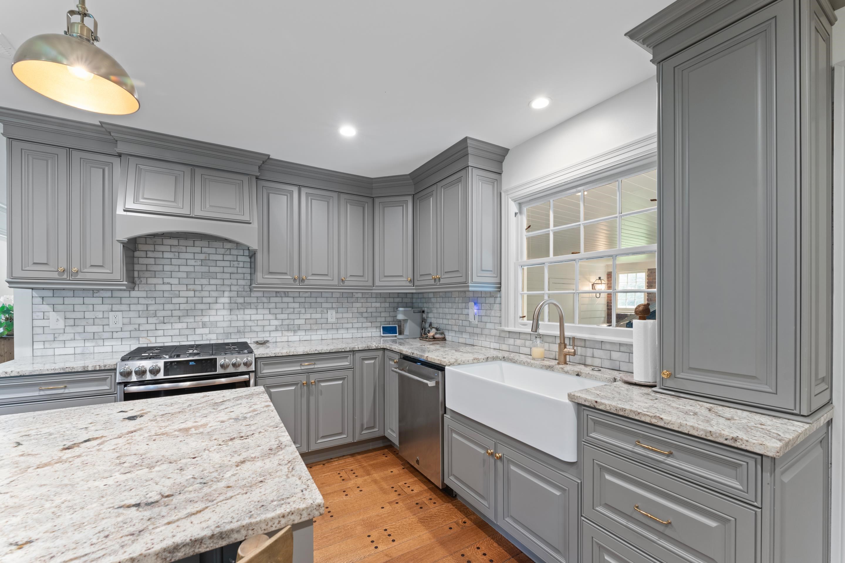 1226 Fair Meadow Road Memphis, TN 38117 - Photo 12 of 40 Kitchen featuring appliances with stainless steel finishes, gray cabinets, backsplash, and light granite counters.