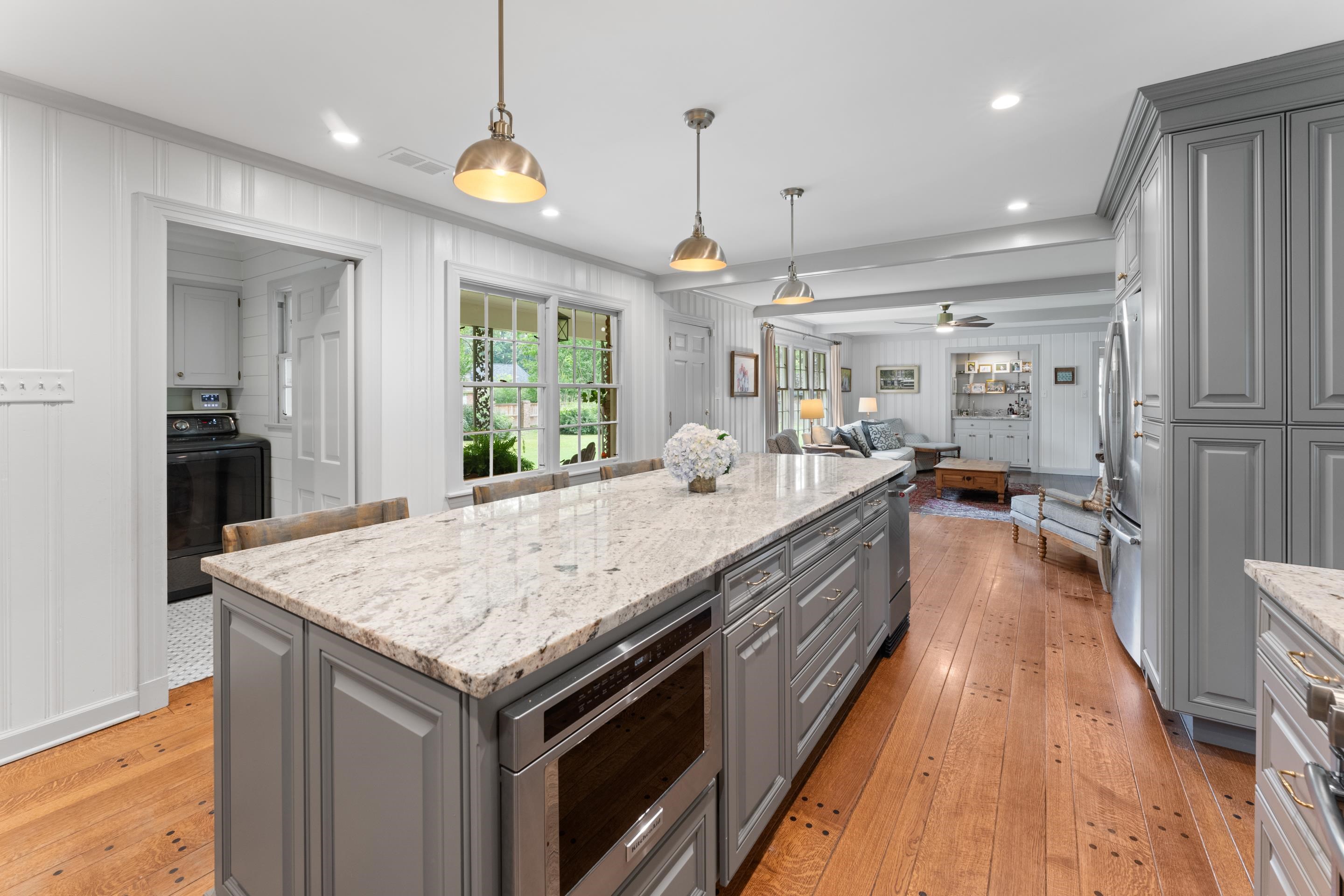 1226 Fair Meadow Road Memphis, TN 38117 - Photo 13 of 40 Kitchen featuring light granite countertops, hardwood flooring, a kitchen island, gray cabinetry, and pendant lighting.