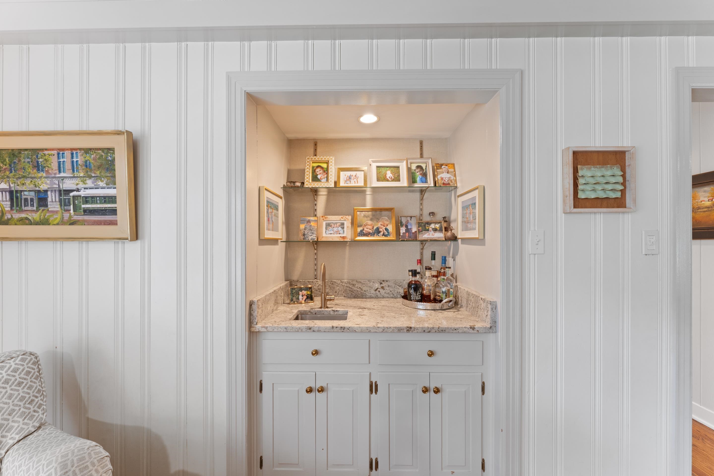 1226 Fair Meadow Road Memphis, TN 38117 - Photo 16 of 40 Wet bar with white cabinets, sink, and light stone countertops.