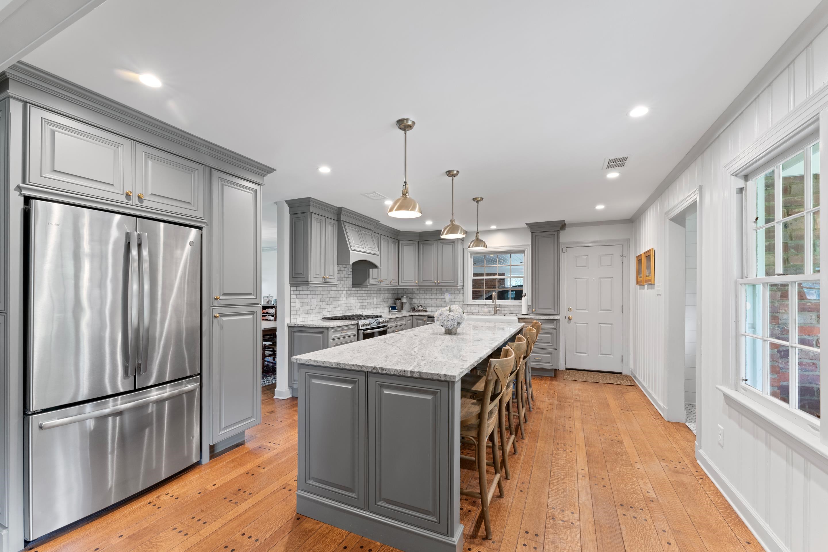 1226 Fair Meadow Road Memphis, TN 38117 - Photo 4 of 40 Kitchen featuring hardwood flooring, custom range hood, gray cabinets, a center island, and appliances with stainless steel finishes.