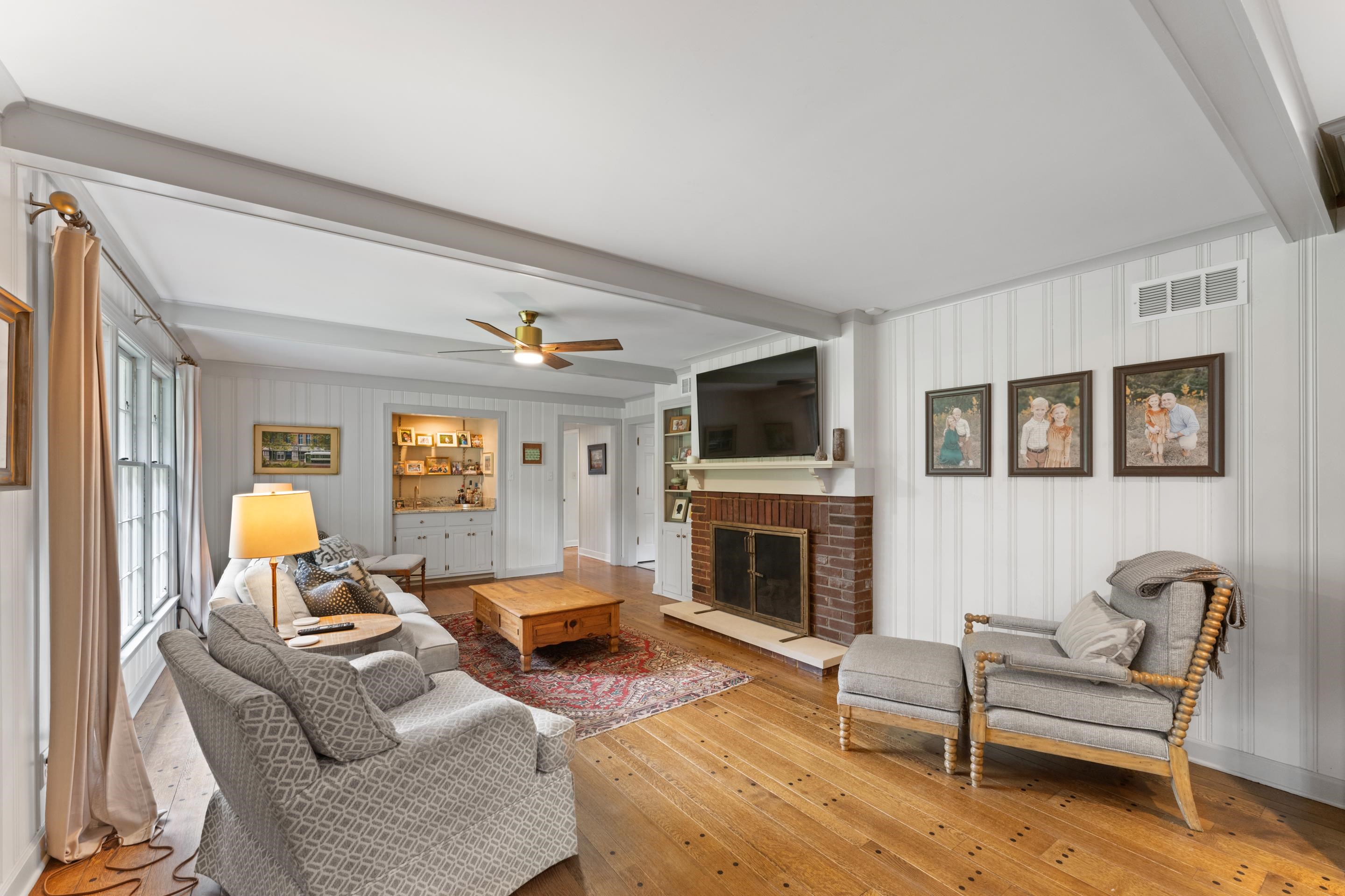 1226 Fair Meadow Road Memphis, TN 38117 - Photo 5 of 40 Great room with a brick fireplace, hardwoodfloors, ceiling fan, wet bar and beam ceiling.
