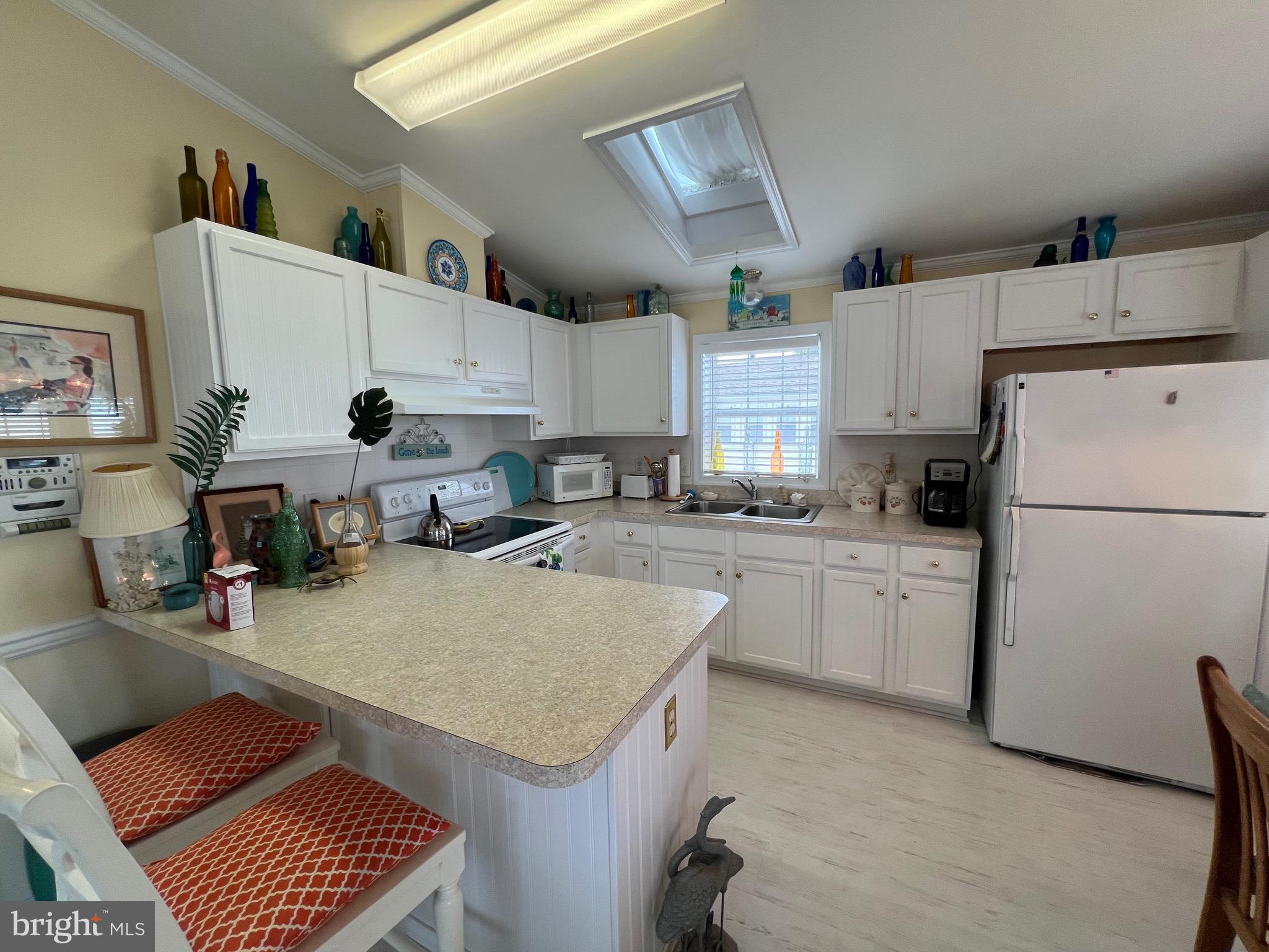 8830 Bay Ridge Drive Berlin, MD 21811 - Photo 13 of 121 a kitchen with a refrigerator a stove a sink dishwasher and white cabinets with wooden floor