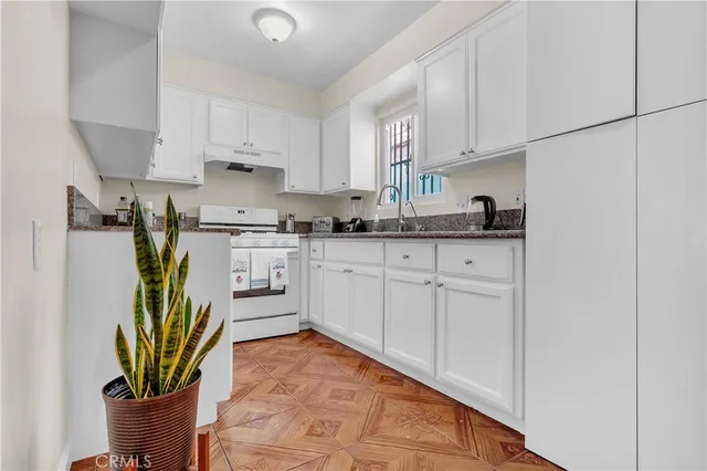 a kitchen with stainless steel appliances granite countertop a sink a stove and cabinets