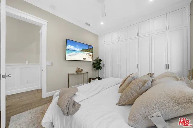 a living room with furniture cabinets and a large window