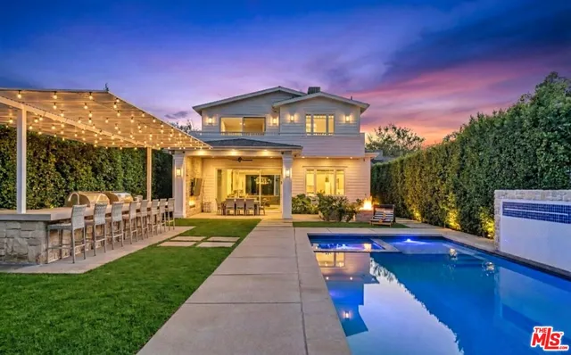 a view of swimming pool with lounge chair and fire pit