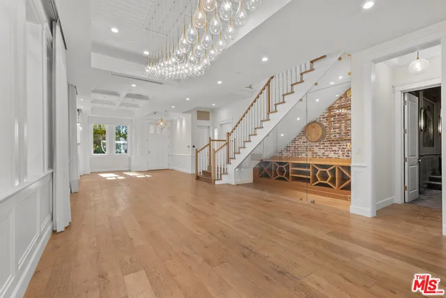 an empty room with wooden floor and staircase