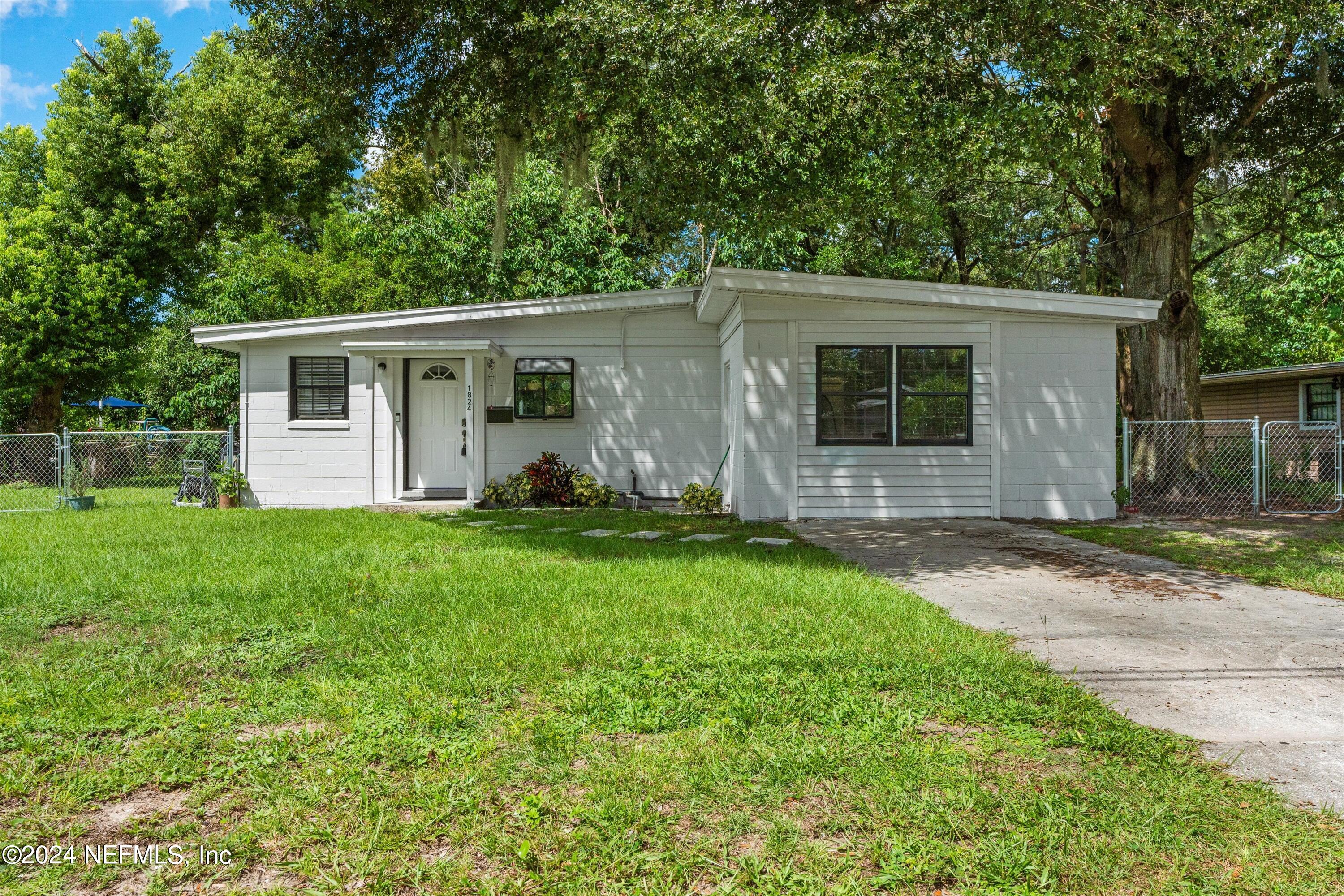 1824 Griflet Road Jacksonville, FL 32211 - Photo 1 of 19 a backyard of a house with potted plants and large tree