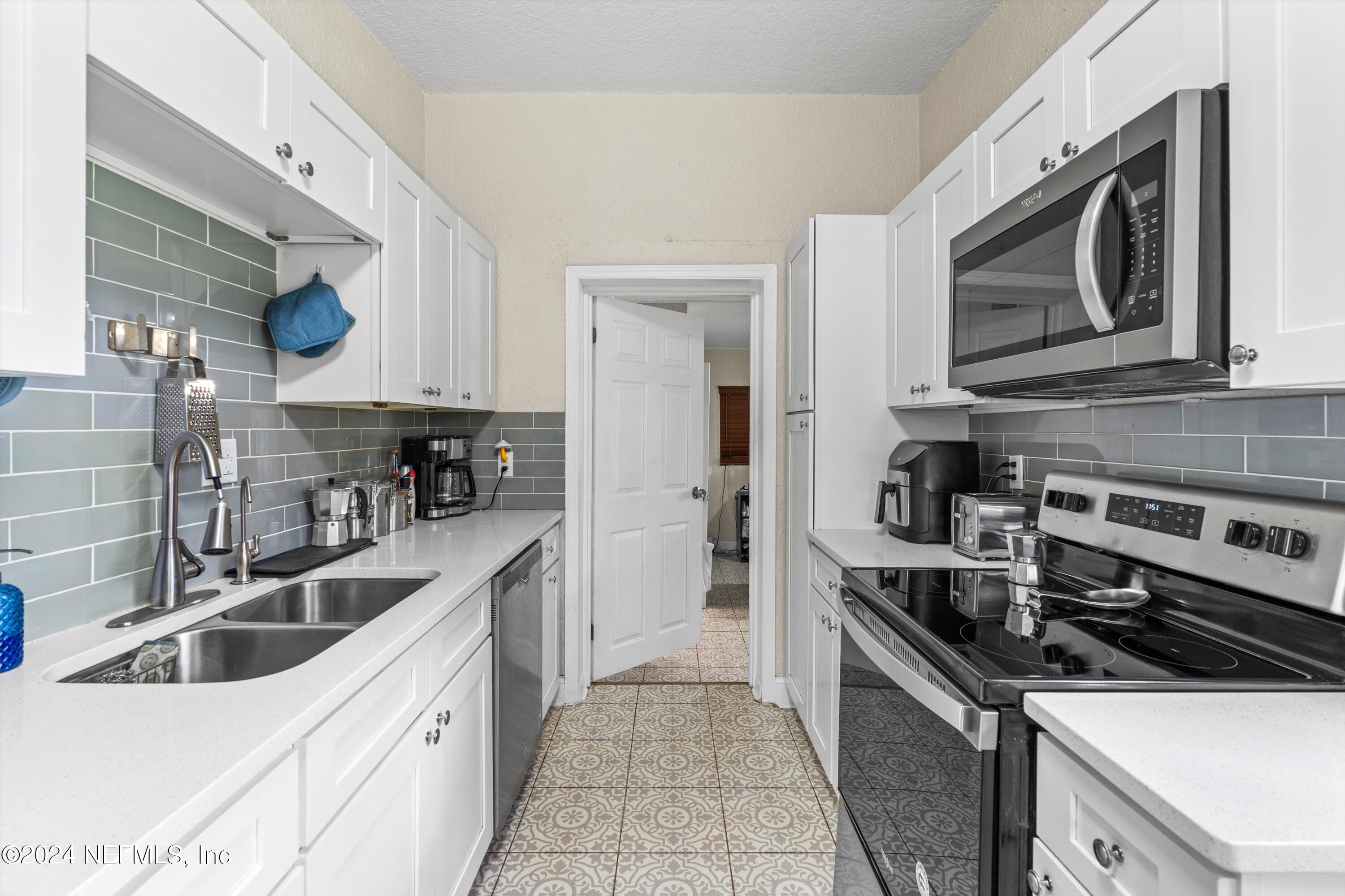 1824 Griflet Road Jacksonville, FL 32211 - Photo 5 of 19 a kitchen with stainless steel appliances a sink a stove and cabinets